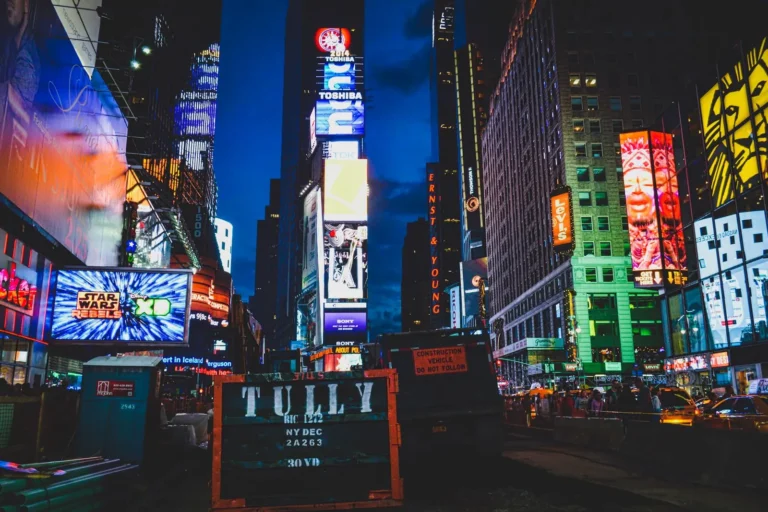 Times Square at night, lit by large brand billboards